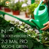 A person is watering plants with a green watering can. The image has a diagonal split with text overlays. Produktbild-Vorschau