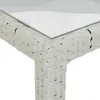 Close-up of the corner of a white rattan table with a glass top. Produktbild-Vorschau