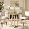 A round dining table with chairs in a dining room setting with a fireplace in the background. Produktbild-Vorschau