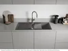 A modern kitchen sink area with a Blanco Adira XL 6 S granite sink in anthracite, a chrome faucet, and various kitchen accessories on the countertop. Podgląd zdjęcia produktu