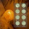 A close-up of a Himalayan salt lamp nightlight plugged into a wall socket, with a graphic overlay detailing its features. Produktbild-Vorschau