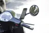 Close-up of a smartphone mounted on a scooter's handlebar, with a mirror in the background. Anteprima dell’immagine prodotto
