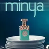 A bottle of perfume is displayed on a stack of white plates against a dark blue background. Anteprima dell’immagine prodotto
