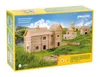The image shows the packaging for a wooden construction set, depicting a village of log houses built on a grassy hill under a blue sky. Anteprima dell’immagine prodotto