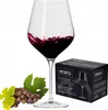 A wine glass filled with red wine, next to a bunch of grapes and a product box. Produktbild-Vorschau