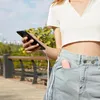 A person holding a phone and a pink portable fan is in their pocket, outdoors. Anteprima dell’immagine prodotto