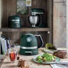 A kitchen counter with a kettle, toaster, stand mixer, bread, and avocado toast. Produktbild-Vorschau