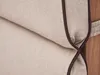 Close-up of a beige cushion with dark brown piping, attached to a wooden structure. Produktbild-Vorschau
