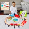 A young boy is sitting on the floor playing with a wooden train set. Produktbild-Vorschau
