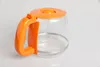 A close-up shot of an empty glass coffee pot with an orange lid and handle. Produktbild-Vorschau