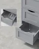 A close-up, angled view of a grey wooden cabinet with several drawers, one of which is partially open, revealing the interior. Náhled obrázku produktu