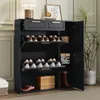 A dark gray shoe cabinet with two drawers and multiple shelves, filled with shoes and boxes, placed in a room with a plant and a lamp. Podgląd zdjęcia produktu