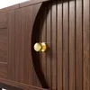 A close-up view of a wooden cabinet with a golden knob. Podgląd zdjęcia produktu