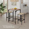 A bar table and two stools are set up in a modern kitchen or dining area, with a plant and window in the background. Produktbild-Vorschau