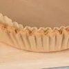 A close-up view of stacked brown paper liners for an air fryer, resting on a wooden surface. Podgląd zdjęcia produktu