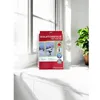 A product package for window insulation film sits on a windowsill next to a plant. Produktbild-Vorschau
