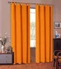 A pair of orange curtains hanging in front of a window, with a dresser and decorative items to the left and chairs to the right. Produktbild-Vorschau
