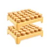 Two yellow plastic stands, each holding multiple small, round, light brown baked goods, are stacked on top of each other against a white background. Náhled obrázku produktu