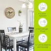A dining room setting with a clock on the wall and a table set for a meal. Produktbild-Vorschau