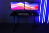 A gaming desk setup with dual monitors, keyboard, and mouse, illuminated by blue LED lights. Voir les images du produit