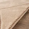 A close-up view of a beige rug with a geometric pattern, lying on a wooden floor. Anteprima dell’immagine prodotto