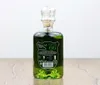 A bottle of green absinthe sits on a wooden table against a white background. Produktbild-Vorschau