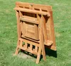 A wooden folding table is shown in a folded position on a grassy lawn. Produktbild-Vorschau