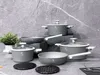 A set of cookware arranged on a textured gray surface. Podgląd zdjęcia produktu