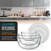 A kitchen counter with cabinets and appliances in the background, and a set of glass bowls with lids in the foreground. Náhled obrázku produktu