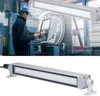 A person in a factory setting operating machinery, with a light fixture above. Podgląd zdjęcia produktu