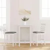 A white bar table with two white bar stools with gray cushions, set against a white wall with natural light coming from windows. Náhled obrázku produktu