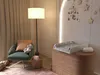 A nursery room with a changing station and a chair. Produktbild-Vorschau