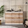 A dresser with six drawers in a room with a tiled wall and a floor lamp. Voir les images du produit