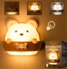 A collage of images showcasing a bear-shaped night light, its packaging, and close-ups of its features. Produktbild-Vorschau