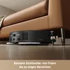 A robot vacuum cleaner is shown cleaning under a brown leather sofa, with a measurement indicating its low profile. Produktbild-Vorschau