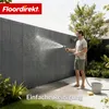 A man is cleaning a fence with a hose in a garden setting. Produktbild-Vorschau