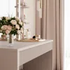 A vanity table with makeup and flowers. Produktbild-Vorschau