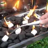 A hand is using a lighter to ignite charcoal briquettes in a grill. Produktbild-Vorschau