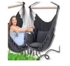 A woman is sitting in a hammock chair outdoors, with grass in the foreground. Produktbild-Vorschau