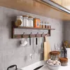 A kitchen shelf with various items like jars, spice containers, and kitchen utensils hanging on hooks. Produktbild-Vorschau