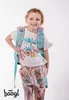 A young girl wearing a backpack and a flamingo-themed outfit, posing against a white background. Náhľad obrázku produktu