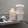 Shampoo and conditioner bottles on a shower shelf with a shower head and foam. Anteprima dell’immagine prodotto