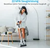 A woman is vacuuming a living room with a cordless vacuum cleaner. Produktbild-Vorschau