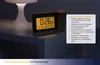 A digital projection alarm clock with a thermometer is shown on a nightstand next to a lamp. Anteprima dell’immagine prodotto