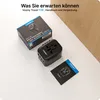 A black VOOMY travel adapter and its packaging are displayed on a white surface, with a wooden partition in the background. Produktbild-Vorschau