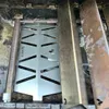Close-up view of a grill's internal components, showing a heat reflector and burner. Podgląd zdjęcia produktu
