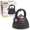 A black whistling kettle with copper accents is shown next to its packaging. Produktbild-Vorschau