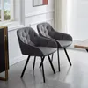 Two gray velvet dining chairs with black legs are shown in a room with a window and blinds. Produktbild-Vorschau