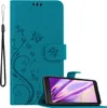 A teal flip phone case with a floral and butterfly design is shown open, with a smartphone placed inside and angled upwards. Náhled obrázku produktu