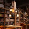A vintage-style chandelier with wooden and metal elements hangs in a room filled with bookshelves. Náhled obrázku produktu
